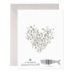 The STARLINGS CONDOLENCE GREETING CARD by E.FRANCES PAPER beautifully features a heart shape created from small bird silhouettes in calming gray tones. The words "So Sorry" are elegantly inscribed at the bottom right corner, complemented by handcrafted watercolor elements that enhance its charm. An envelope is partially visible in the background, adding to its presentation.