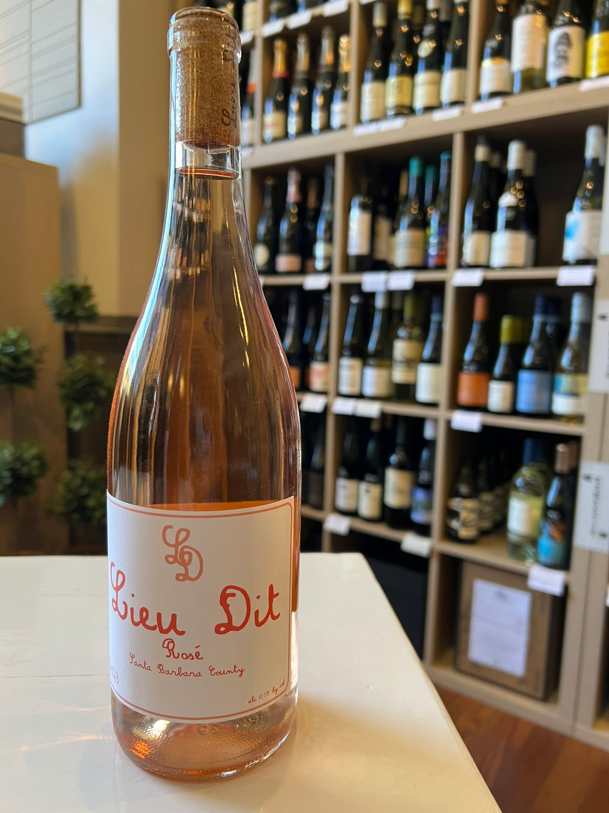 A bottle of LIEU DIT &#39;ROSÉ OF CABERNET FRANC&#39; 2023 by WINE: KELLOGG SELECTIONS features a cork top, a &quot;Lieu Dit Rosé&quot; label with red script and &quot;LD&quot; monogram, and holds light pink wine crafted from Cabernet Franc in Santa Barbara.