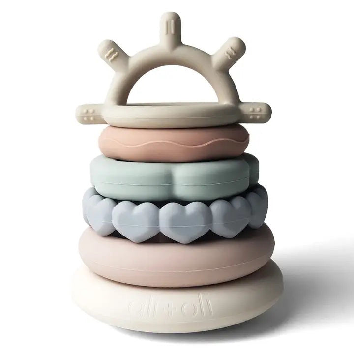 Introducing the SILICONE SUN STACKING RING TOWER from ALI + OLI: a set of BPA-free silicone stacking rings in soft pastel hues. The rings come in various shapes and textures, including hearts, and feature a sun-shaped topper on a sturdy base. This baby development toy is designed to promote motor skills and creativity.