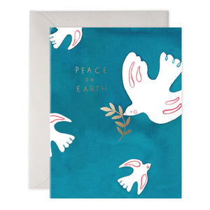 The PEACE DOVES HOLIDAY CARD by E.FRANCES PAPER features a handcrafted watercolor design of lovely white doves holding olive branches on a teal background, with "Peace on Earth" elegantly scripted in gold. This exquisite card is partially nestled inside a light gray envelope and proudly made in the USA.