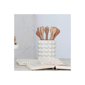 The CANISTER WITH RAISED DOTS & ACACIA LID by CREATIVE COOP is a beige ceramic stoneware container featuring a unique, bubble-like texture and an acacia wood lid with a spherical knob. Ideal for kitchen storage, this stylish and functional piece blends modern design with decorative flair.