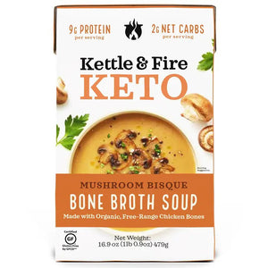 Box of KETTLE & FIRE - MUSHROOM BISQUE KETO SOUP, featuring an image of the soup garnished with herbs and mushrooms. The label highlights 9g protein, 2g net carbs per serving, and the inclusion of organic, free-range chicken bones. Gluten-free certified. Net weight: 16.9 oz (479g).