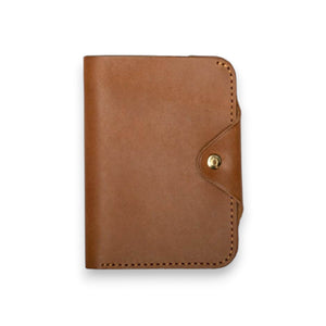The WP STANDARD - PASSPORT WALLET by WP STANDARD is shown open on a white background with a U.S. passport on the right and an empty left pocket—a stylish full-grain leather travel essential.