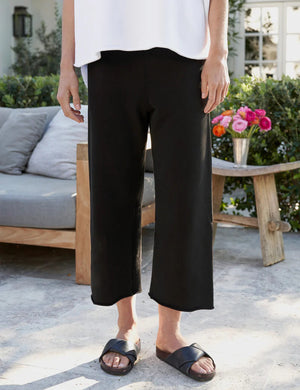 A pair of black, wide-leg pants is laid flat against a plain, light background. The FRANK & EILEEN - CATHERINE Favorite sweatpant features an elastic waistband with a drawstring for an adjustable fit. The fabric appears to be soft and comfortable, suitable for casual wear.