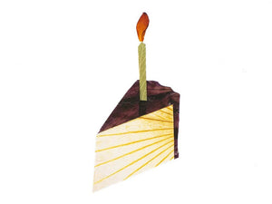 This charming CAKE BIRTHDAY CARD by PETAL PEOPLE PRESS showcases an illustration of a single slice of chocolate frosted cake, adorned with a vertical candle and flickering flame. The simple elegance against a white background evokes the charm of pressed flower art.