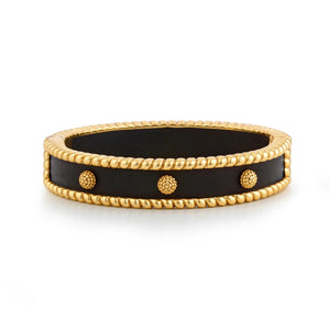 The CAPUCINE DE WULF - BERRY SMALL HINGED EBONY BANGLE combines a sleek black band with small 18K gold embellishments and twisted rope details, featuring an anti-tarnish finish for a sophisticated, handcrafted look.