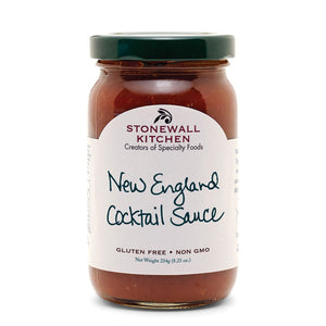 A jar of STONEWALL KITCHEN - New England Cocktail Sauce with a green lid. The label reads "Creators of Specialty Foods" and "New England Cocktail Sauce." Infused with horseradish, this gluten-free and non-GMO sauce is perfect for shrimp cocktail. Net weight: 234g (8.25 oz).