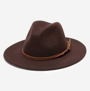 The BILLIE FEDORA HAT by WYETH is a tan wool felt fedora with a leather trim, showcasing a pinched crown and mid brim, beautifully displayed against a plain white background.