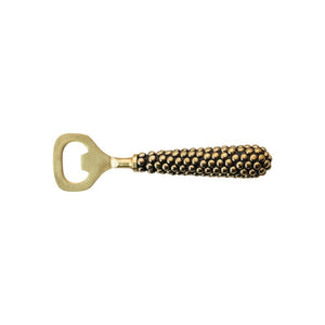 The CREATIVE COOP STAINLESS STEEL BOTTLE OPENER WITH CAST BRASS BEADED HANDLE boasts a golden finish and a corn cob-style design with intricate metallic bumps, offering an elegant nod to classic beaded brass aesthetics while being packaged sustainably for an eco-friendly touch.