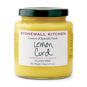 A glass jar with a dark green lid contains STONEWALL KITCHEN - LEMON CURD. The label reads "STONEWALL KITCHEN Creators of Specialty Foods, Lemon Curd, COMPANY CLASSIC, GLUTEN FREE, Net Weight 326g (11.5 oz.)." The curd is yellow and offers the sweet tartness of traditional English-style custard.