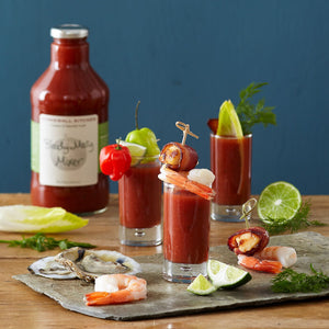 A bottle of STONEWALL KITCHEN - BLOODY MARY MIXER is displayed with a silver cap and a white label featuring green text. This gourmet mixer is gluten-free and non-GMO, containing 24 fluid ounces (710 milliliters) of product—perfect for your next brunch gathering.