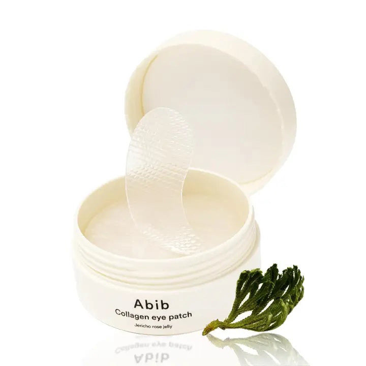 A white jar labeled &quot;ABIB - COLLAGEN EYE PATCH JERICHO ROSE JELLY 60 PCS&quot; from ASIAN BEAUTY WHOLESALE with a translucent eye patch being lifted—ideal for under-eye bags—sits beside a small green plant.