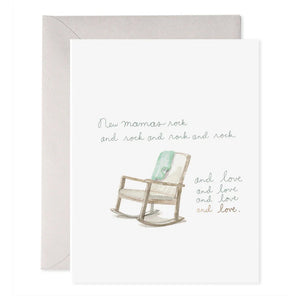 The NEW MAMAS ROCK GREETING CARD by E.FRANCES PAPER showcases a simple design with a gentle illustration of a baby sleeping in a crescent-shaped cradle, akin to an artisanal watercolor painting. "E.FRANCES" and website information are elegantly printed at the bottom. The card is paired with a light gray envelope.