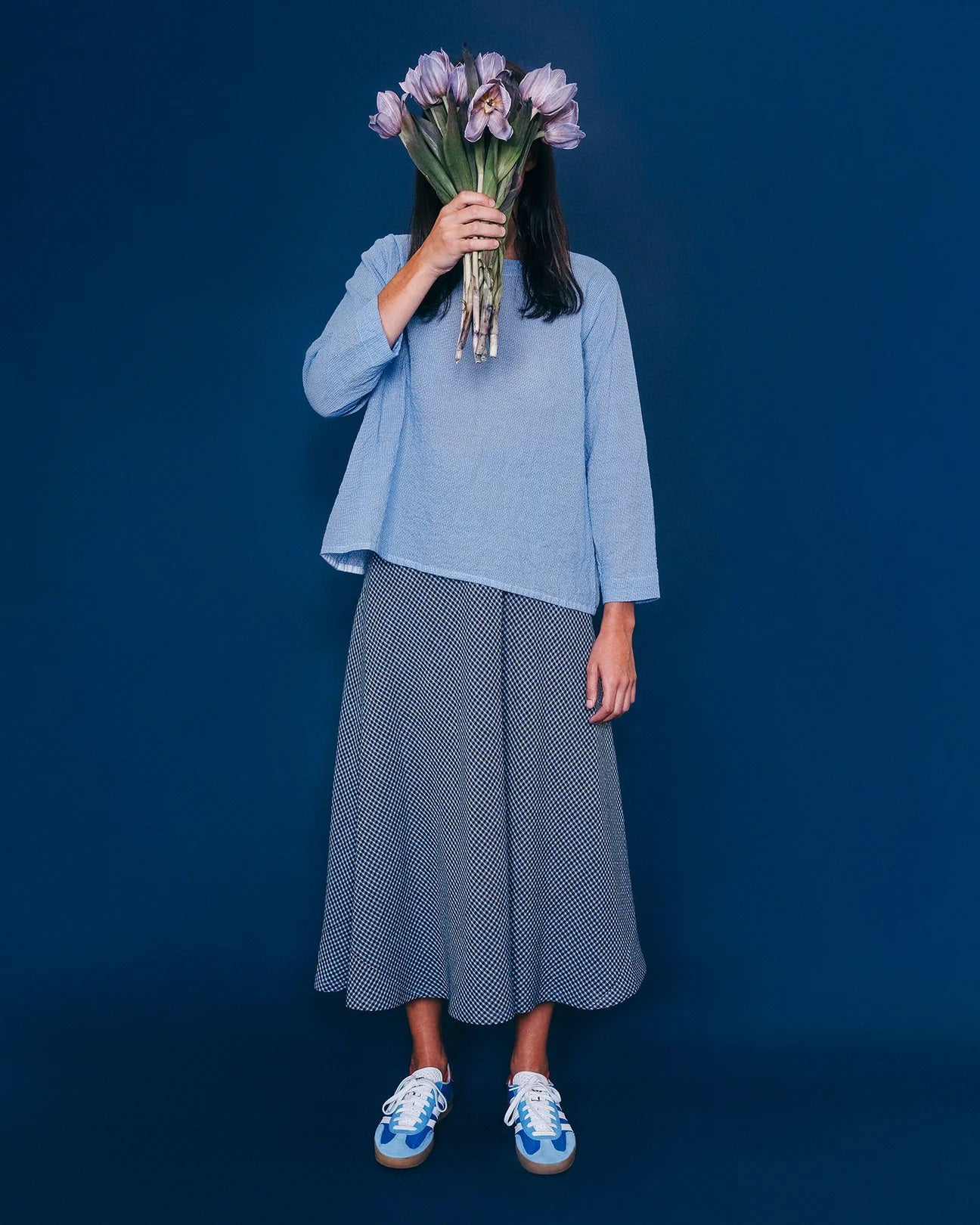 The Marnie Skirt by THE LITTLE PROJECT, in marine gingham, is a long flared A-line made from high-quality linen. Crafted in Los Angeles, it features a small black and white polka dot pattern laid flat on a white background.