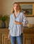 The Eileen Relaxed Button Up Shirt in Gray Blue by Frank & Eileen features a chest pocket, rolled-up sleeves, and bust-flattering button placement. Its inside label says "Frank & Eileen EST. 1947," and it is shown laid flat against a white background.