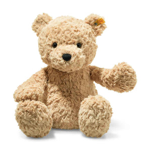 The STEIFF - JIMMY TEDDY BEAR, from STEIFF, is a fluffy beige stuffed bear with a friendly expression. It features a small, round black nose and eyes. Made from plush fabric, it has an ear tag and sits upright against a plain white background.