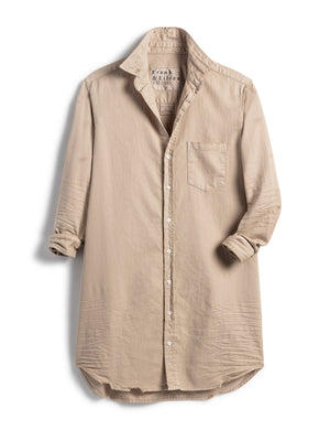 The FRANK & EILEEN Mary Classic Shirtdress in Famous Denim is displayed. This beige long-sleeve button-down shirt features a single chest pocket on the left side and has rolled sleeves. The fabric appears soft and slightly wrinkled, giving it a casual, relaxed look reminiscent of hand-distressed denim.