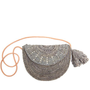 Introducing the MAR Y SOL - LILA CROSSBODY by MAR Y SOL, a semi-circular woven crossbody bag showcasing light and dark gray tones with an elegant braided design. The bag features a long, thin peach-colored strap and a small removable gray tassel hanging from one end. Its intricate weaving patterns create a rustic appearance reminiscent of crocheted raffia.