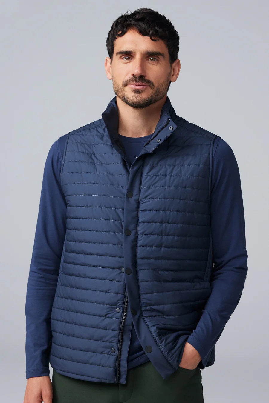 The MACK WELDON - WARMKNIT AIR PUFFER VEST is a sleeveless, dark navy vest with Thinsulate fill, high collar, snap-button front, and horizontal quilting, shown laid flat on a white background.