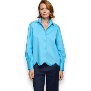 A person with short hair wears a bright green HINSON WU Blaire Scallop Hem Shirt and light blue stretch cotton jeans. One hand is in their pocket, and they sport a bracelet against a plain white background.