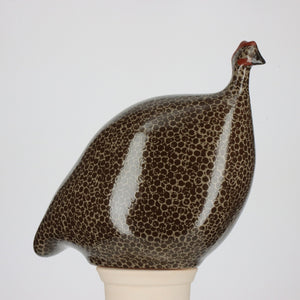 Handcrafted by Les Ceramiques de Lussan, the Large Pecking Ceramic French Guinea in Black Spotted Grey embodies the essence of a guinea fowl with its dark spotted pattern, small red crest, and stylized rounded form. The sculpture is elegantly displayed against a plain white background to emphasize its intricate details.