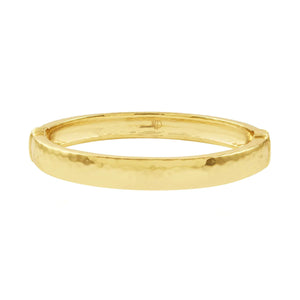 The CAPUCINE DE WULF - CLEOPATRA OVAL HINGED BANGLE MEDIUM/LARGE is a striking piece that combines the luxurious shine of 18K flash gold plating with a smooth, rounded design. This hammered gold bangle from CAPUCINE DE WULF exudes modern elegance through its simple yet textured surface.