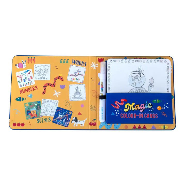 An open children&#39;s activity book by FLOSS &amp; ROCK, the &quot;PETS WATER PEN AND CARDS,&quot; features colorful sections labeled &quot;Words,&quot; &quot;Numbers,&quot; and &quot;Scenes.&quot; Included are drawing examples, a blank coloring page, and a closed pouch labeled &quot;Magic Colour-in Cards&quot; containing a marker pen. This eco-friendly coloring book showcases travel-friendly toys in vibrant orange, blue, and white.