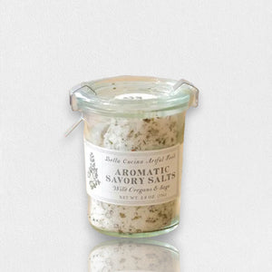 The BELLA CUCINA - WILD OREGANO & SAGE SALT is a small jar featuring a metal clasp and an herb-adorned label, blending European flat crystal salt with wild oregano and crushed sage leaves.