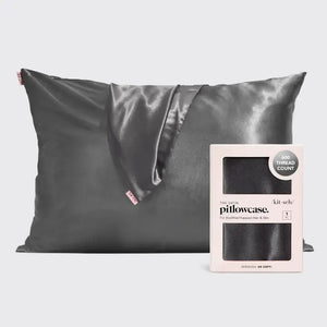 A satin pillowcase with a beige and white leopard print design is displayed against a plain background. To the right of the luxurious pillowcase is its packaging, which reads "SATIN PILLOWCASE" by KITSCH and highlights its 600-thread count and benefits for frizz-free hair and healthy skin.