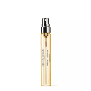 A slim, cylindrical bottle of MOLTON BROWN Gingerlily Eau de Toilette in an amber hue is shown against a plain white background. The bottle features a silver spray nozzle and cap, with the brand name and fragrance details elegantly printed on the front, hinting at its floral notes.