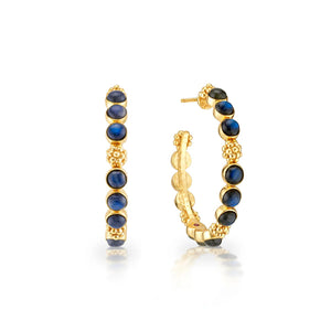 A pair of CAPUCINE DE WULF - BERRY GEM MEDIUM BLUE LABRADORITE EARRINGS in 18K gold, featuring a row of round blue labradorite gemstones. Each earring is intricately detailed with small gold beads surrounding the stones. One earring is positioned to show the front, and the other displays the side view.