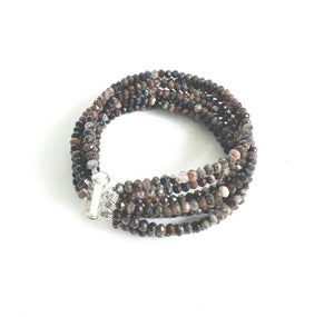 The ANN LIGHTFOOT Eight Strand Faceted 4mm Pietersite Bracelet showcases multiple strands of small, faceted rondelles in an array of brown and black shades. It is designed in a coiled circular form with a rectangular stainless steel clasp.