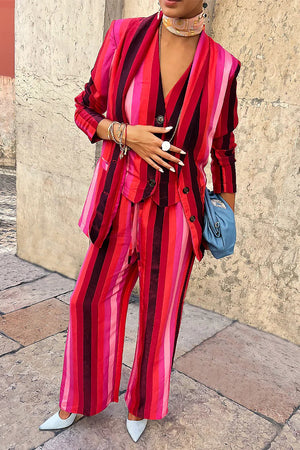 The NEVER FULLY DRESSED - ELISSA TROUSER by NEVER FULLY DRESSED features vertical pink stripes in shades of red and maroon. These breathable viscose wide-leg pants come with an elastic waistband and a drawstring for adjustment.