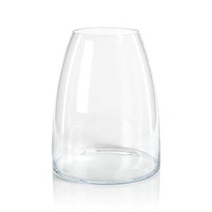 The KOBAYASHI GLASS VASE by ZODAX is a clear, slightly tapered, cylindrical glass vase with a rounded bottom and smooth surface. It reflects light beautifully and features no decorations or engravings. The vase stands upright on a white, reflective surface. For this item, INSTORE PICKUP ONLY; please check the product dimensions before purchasing.