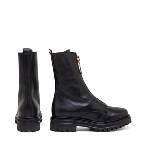 The MICHELE LOPRIORE MINSK Boot with Fur is a sleek black combat boot made of genuine leather featuring a front zipper closure and a chunky sole. The boot boasts a slightly rounded toe and includes a pull tab at the back for ease of wearing. Made in Italy, the sole has deep treads for enhanced grip and durability.