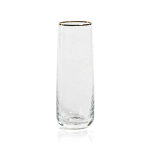 A sophisticated, clear Negroni Hammered Stemless Flute from the brand Zodax, featuring a subtly textured design and a delicate gold rim at the top, elegantly displayed upright against a white background.