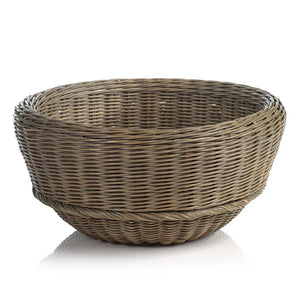 The MONTEVERDE RATTAN BOWL by ZODAX is a round, empty wicker basket featuring a light brown finish. Measuring 18.5 in x 9 in, this basket showcases a tightly woven pattern with a slightly flared rim and a bottom that is slightly raised off the surface. It is displayed against a plain white background.