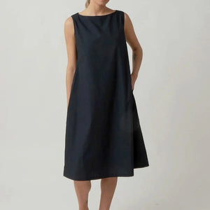 The KATHARINA HOVMAN Sleeveless Dress in Heavy Taffeta features a purist style with pleated texture, creating an elegant appearance. Its slightly shiny taffeta fabric adds sophistication to the outfit.