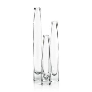 The ZODAX TATE SLIM CLEAR GLASS VASE - SHORT, featuring a narrow neck and wider base, measures 2.5 in x 13.5 in and is shown against a plain white background.