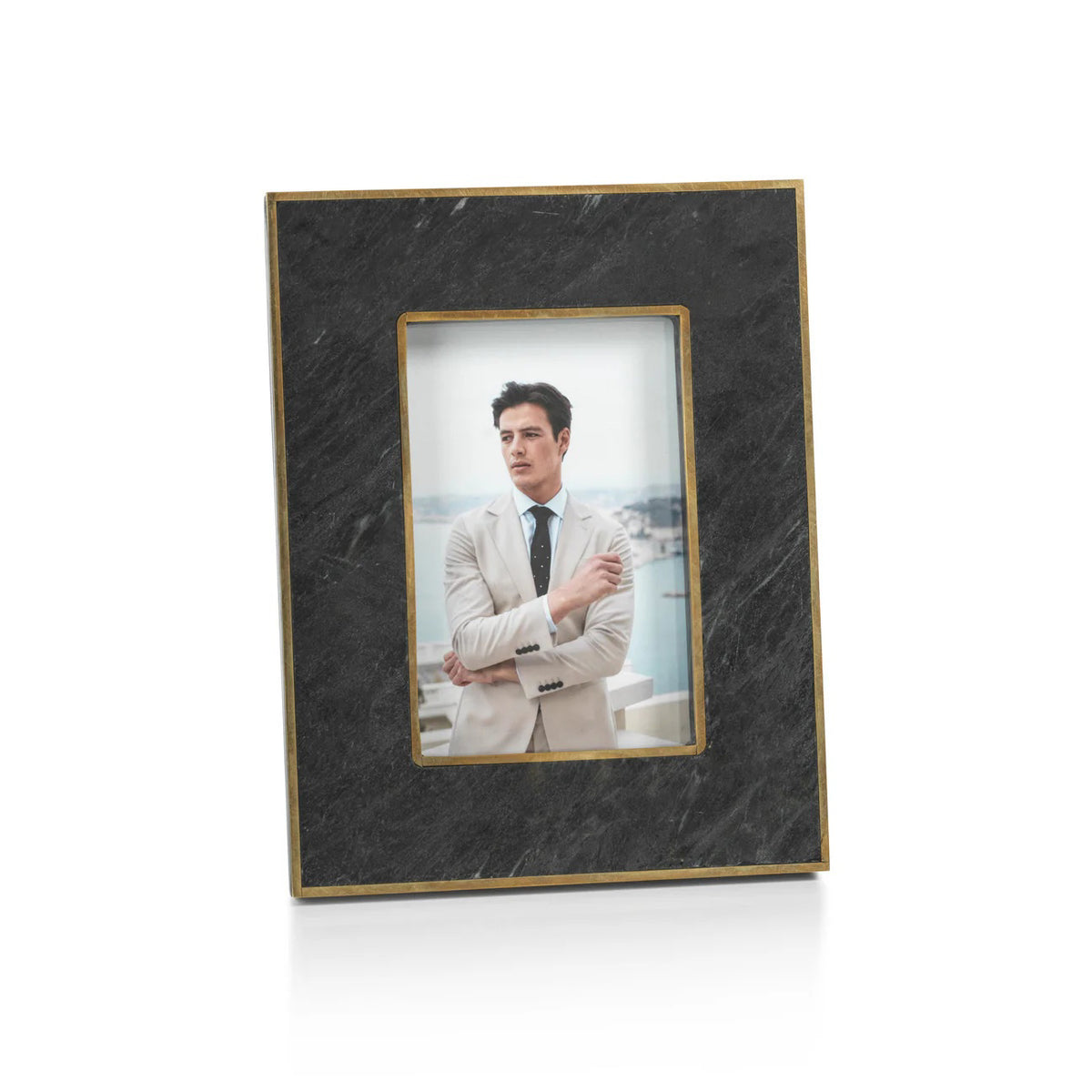Two ZODAX RENNES GRANITE PHOTO FRAME 4X6 frames sit on a beige surface. The left frame displays a man in a light suit, while the right holds a woman in a black polka dot dress.