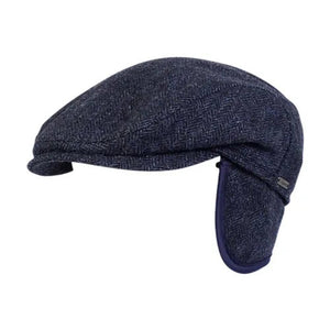 The WIGENS IVY SLIMP HERRINGBONE CAP is a dark gray Shetland wool flat cap with ear flaps, shown in side view on a white background.