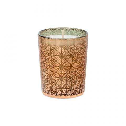 A LAFCO - WOODLAND SPRUCE VOTIVE candle in a patterned glass holder is placed beside its matching box. The box, adorned with green and gold geometric designs and a black ribbon handle, is labeled "LAFCO New York Woodland Spruce." The partially transparent glass of the candle reveals the wax inside, evoking the scent of an evergreen spruce.