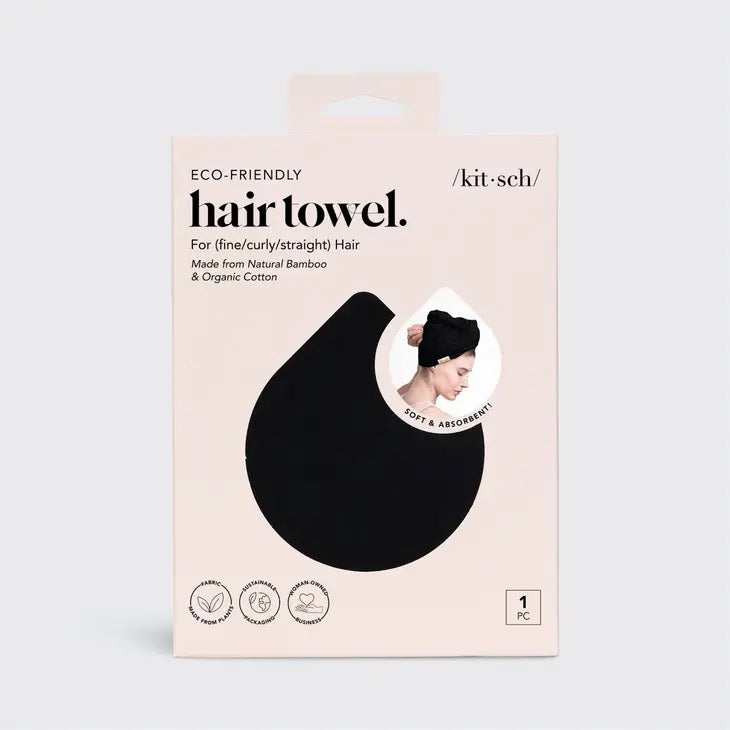 The QUICK DRY HAIR TOWEL by KITSCH is packaged in a cream-colored box, detailed with a black droplet shape and an inset image of someone wearing the highly absorbent towel. Designed for fine, curly, or straight hair, it's crafted from organic cotton and bamboo. The text and icons on the packaging are clearly visible.