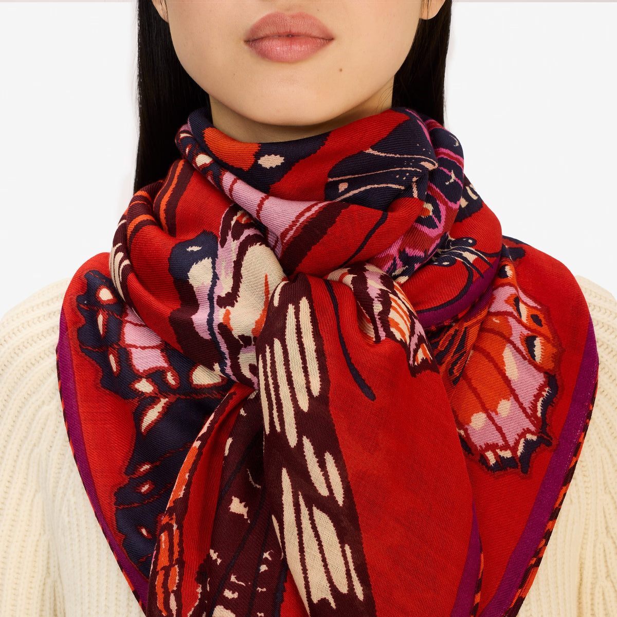 The INOUI EDITIONS PAPILLONS Square Wool Scarf in red features colorful butterflies in pink, orange, purple, and brown across a vibrant 130x130cm design—an eye-catching and versatile accessory for any occasion.