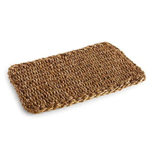 The SEAGRASS RECTANGULAR PLACEMAT by NAPA HOME AND GARDEN is crafted from brown seagrass fibers, featuring a rectangular shape with a coarse texture and visible loops. The edges are neatly finished, and the placemat is displayed on a plain white background.