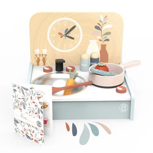 Introducing the SPEEDY MONKEY - TABLE KITCHEN SET by SPEEDY MONKEY: a wooden toy kitchen set designed for ages 3+ years. Crafted from sustainably sourced wood, this set includes a stove, a pan with a tomato, a carrot, a turnip, salt and pepper shakers, and a faucet. The decorative backdrop features charming clock and plant designs. Additionally, the set comes with a recipe card booklet to inspire little chefs.