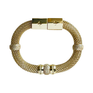 The HOLST & LEE - LUXE MESH BRACELET is a gold-plated mesh bracelet featuring a rectangular magnetic clasp and adorned with small gold and diamond-accented rings. The design is elegant, with a touch of sparkle from the diamond embellishments.