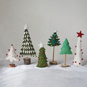 Introducing the HANDMADE WOOL FELT TREE WITH STAR AND POM POMS by CREATIVE COOP, crafted in layered green fabric and embellished with small red and multi-color pom poms. This festive tree is crowned with a white star, offering a simple yet charming design set against a plain white background.