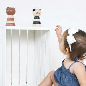 A white packaging box is labeled at the top with "WEE GALLERY" and at the bottom with "PANDA WOOD STACKER." The box features an image of a wooden stacker toy resembling a panda, consisting of alternating black and natural wood rings, designed to enhance fine motor skills through creative play.