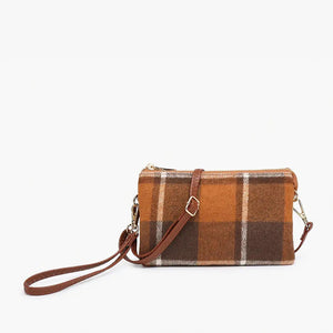 The PLAID CROSSBODY WRISTLET by JEN & CO boasts a blue plaid design on vegan leather, showcasing a grid pattern with brown lines against a plain white background. It features a detachable strap and zipper closure, highlighted by gold-tone hardware on the wristlet strap.